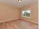 A bright bedroom with a large window, neutral walls, and modern light-colored wood flooring at 5607 Fulton Ridge Dr, Indian Trail, NC 28079