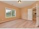 A bright bedroom with a large window, neutral walls, and modern light-colored wood flooring at 5607 Fulton Ridge Dr, Indian Trail, NC 28079