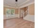 Elegant dining room featuring modern light fixture, neutral walls, wainscoting and light-colored wood flooring at 5607 Fulton Ridge Dr, Indian Trail, NC 28079
