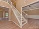 Spacious foyer featuring wood staircase, neutral walls, modern lighting, and light-colored wood flooring at 5607 Fulton Ridge Dr, Indian Trail, NC 28079