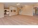 Open living space featuring light vinyl flooring, neutral walls, a staircase, and a partial view into kitchen at 5607 Fulton Ridge Dr, Indian Trail, NC 28079