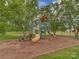 Community playground with slide, climbing structure, and benches surrounded by beautiful mature trees at 5607 Fulton Ridge Dr, Indian Trail, NC 28079