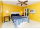 Yellow bedroom featuring a comfortable bed, ceiling fan and outdoor views at 6119 Bittersweet Ln, Charlotte, NC 28270