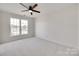 Spacious bedroom with neutral carpet, white walls, and a large window overlooking the neighborhood at 622 Bayou Cir, Clover, SC 29710