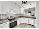 Bright kitchen features stainless steel appliances, patterned backsplash, granite countertops, and modern white cabinetry at 622 Bayou Cir, Clover, SC 29710