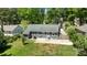 An aerial view of the home surrounded by mature trees, a manicured lawn, and a concrete patio at 6406 Old Meadow Rd, Charlotte, NC 28227