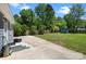 The backyard features a well-manicured lawn, mature trees, a concrete patio, and a storage shed at 6406 Old Meadow Rd, Charlotte, NC 28227