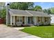 Charming one-story home with a beautifully landscaped front yard and gray brick exterior at 6406 Old Meadow Rd, Charlotte, NC 28227