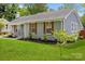 Charming one-story home with a beautifully landscaped front yard and gray brick exterior at 6406 Old Meadow Rd, Charlotte, NC 28227