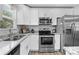 Updated kitchen with stainless steel appliances, granite countertops, and modern white cabinetry at 6406 Old Meadow Rd, Charlotte, NC 28227