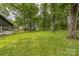 Expansive backyard featuring mature trees and a view of the home's exterior at 6641 Pawnee Dr, Charlotte, NC 28214