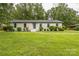 Charming brick home with a blue front door, well-manicured lawn, and mature landscaping at 6641 Pawnee Dr, Charlotte, NC 28214