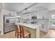 Modern kitchen with a kitchen island, stainless steel appliances, white cabinets, and stylish lighting fixtures at 6641 Pawnee Dr, Charlotte, NC 28214