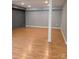 Spacious basement area with brick accent wall and hardwood floors at 715 Gentry Pl, Charlotte, NC 28210