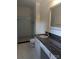 This bathroom has a granite countertop, white vanity, framed mirror and tiled shower and floors at 715 Gentry Pl, Charlotte, NC 28210