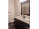 A bathroom features a dark vanity, a pinkish granite countertop, a stained framed mirror, and a tiled shower at 715 Gentry Pl, Charlotte, NC 28210