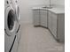 The laundry room features matching washer and dryer, tile floors, and gray cabinets at 715 Gentry Pl, Charlotte, NC 28210