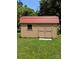 A sturdy and well-kept storage shed with a metal roof sits in the lush green backyard at 715 Gentry Pl, Charlotte, NC 28210