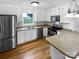 Well-lit kitchen featuring white cabinets, stainless appliances, and hardwood flooring at 7308 Pleasant Hill Church Rd, Marshville, NC 28103