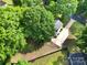 An aerial view of a home featuring a long driveway, mature trees, and a lush green lawn at 8514 Timber Crest Cir, Charlotte, NC 28226