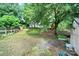 This backyard features green grass, mature trees, and a wooden fence at 8514 Timber Crest Cir, Charlotte, NC 28226
