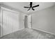 This bedroom features gray walls, gray carpeting, a ceiling fan and a double closet at 8514 Timber Crest Cir, Charlotte, NC 28226