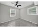 This bedroom features gray walls, gray carpeting, a ceiling fan and two windows at 8514 Timber Crest Cir, Charlotte, NC 28226