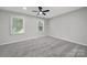 This bedroom features gray walls, gray carpeting, a ceiling fan and two windows at 8514 Timber Crest Cir, Charlotte, NC 28226