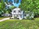 Charming two-story home with light blue siding, dark shutters, green lawn, and mature trees at 8514 Timber Crest Cir, Charlotte, NC 28226