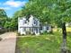 Charming two-story home with light blue siding, dark shutters, green lawn, and mature trees at 8514 Timber Crest Cir, Charlotte, NC 28226