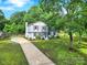 Charming two-story home with light blue siding, dark shutters, green lawn, and mature trees at 8514 Timber Crest Cir, Charlotte, NC 28226