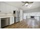 Open kitchen layout boasts stainless steel appliances, white cabinets, and hardwood floors at 8514 Timber Crest Cir, Charlotte, NC 28226