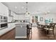 Bright kitchen boasts white cabinetry, stainless steel appliances, and a granite island with seating for three at 8840 Mullis Forest Ct, Mint Hill, NC 28227