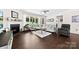 Spacious living room with fireplace, ceiling fan, and large windows at 8840 Mullis Forest Ct, Mint Hill, NC 28227