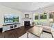 Cozy living room with a fireplace, mounted TV, and plenty of natural light at 8840 Mullis Forest Ct, Mint Hill, NC 28227