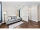 Cozy living room with gray sofa, modern chandelier, trim molding, and large windows for ample natural light at 8840 Mullis Forest Ct, Mint Hill, NC 28227