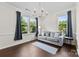 Light-filled living room boasts a comfortable gray sofa, dark hardwood floors, and large windows with scenic views at 8840 Mullis Forest Ct, Mint Hill, NC 28227