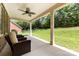 Relax on this covered patio, featuring ceiling fan and comfortable seating, overlooking the expansive backyard at 8840 Mullis Forest Ct, Mint Hill, NC 28227