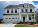 Two-story home featuring white siding, a blue front door, and an attached two-car garage at 885 Regulus Ct # 42, York, SC 29745