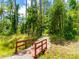 A walking path with a red wooden bridge in the woods with green trees and gravel ground at 922 Bunker Trce, Rock Hill, SC 29730