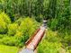 A red wooden bridge surrounded by green trees and bushes on each side of a gravel walking path at 922 Bunker Trce, Rock Hill, SC 29730