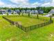 A dog park surrounded by a black metal fence with homes, cars, and trees in the background at 922 Bunker Trce, Rock Hill, SC 29730