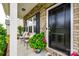 Close-up of a charming front porch with seating, plants, and a black front door at 922 Bunker Trce, Rock Hill, SC 29730