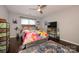 Bright bedroom with a colorful comforter, dark floors, and a ceiling fan at 9239 N Vicksburg Park Ct, Charlotte, NC 28210