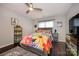 Well-lit bedroom with a vibrant floral comforter and a modern ceiling fan at 9239 N Vicksburg Park Ct, Charlotte, NC 28210