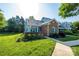 Exterior view of a single-story home with a brick facade, a manicured lawn, and mature trees at 9239 N Vicksburg Park Ct, Charlotte, NC 28210