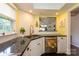 Well-lit kitchen featuring white cabinets and dark countertops, with a window over the sink at 9239 N Vicksburg Park Ct, Charlotte, NC 28210