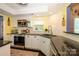 Well-lit kitchen featuring white cabinetry, modern stainless steel appliances, and dark countertops at 9239 N Vicksburg Park Ct, Charlotte, NC 28210