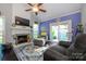 Cozy living room boasts a fireplace, ceiling fan, and sliding glass doors to the backyard at 9239 N Vicksburg Park Ct, Charlotte, NC 28210