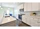 This open kitchen has a marble backsplash, white cabinets, stainless steel appliances, and a dining area at 104 Rockridge Point Dr, Mooresville, NC 28117